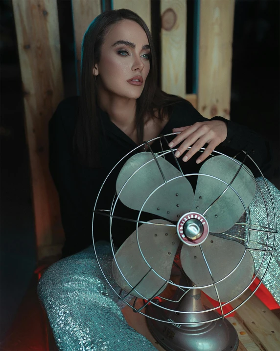 the woman poses with a fan by the table