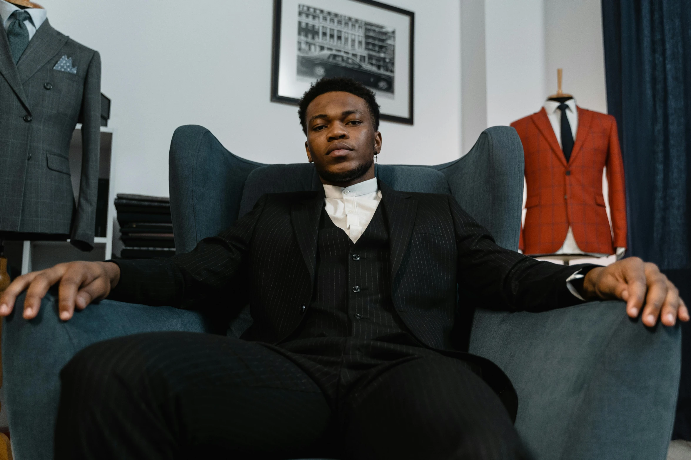 a man sitting in a chair with suit and tie on