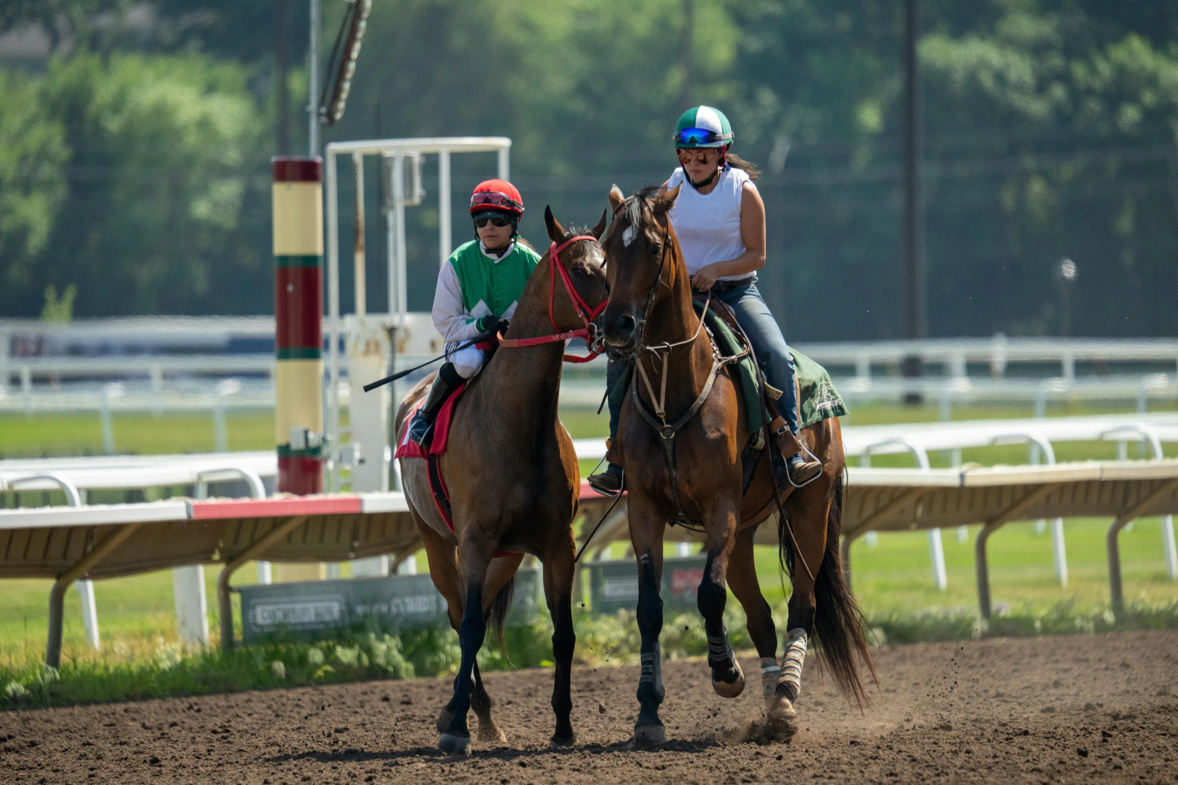 people are riding horses on the track at a horse race