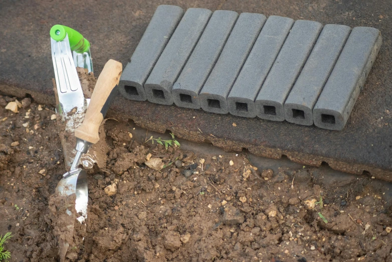 a tool and a gardening fork that are stuck in some soil