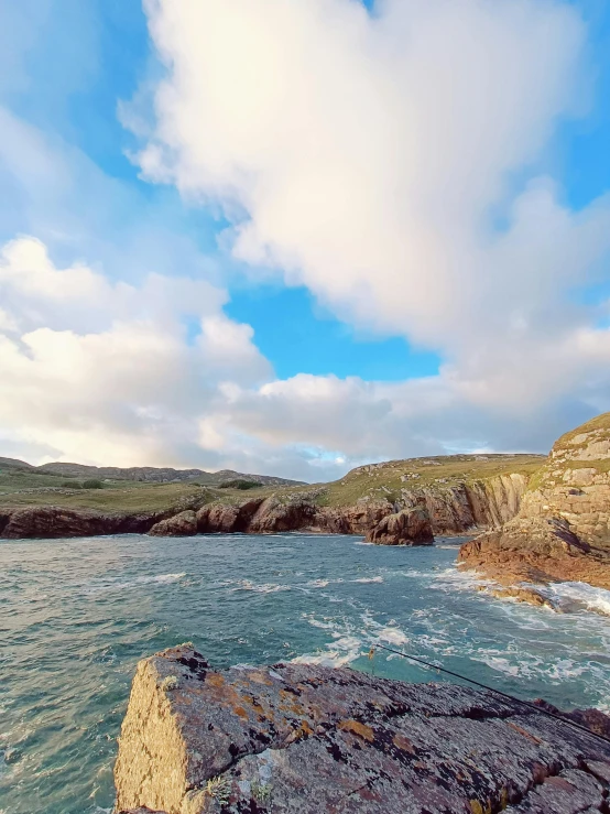 an ocean with lots of blue water and green hills