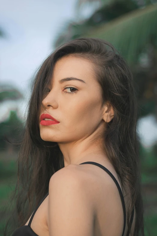 a beautiful woman with red lipstick posing for the camera