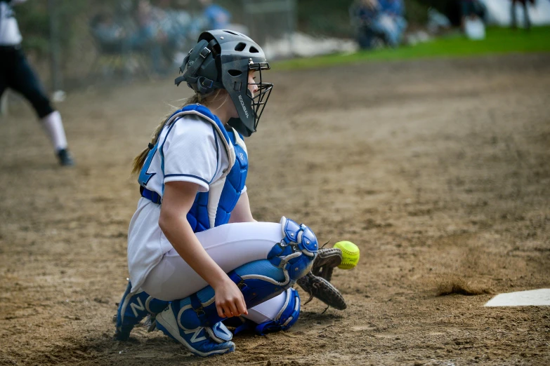 a  in the batting box looking at her baseball