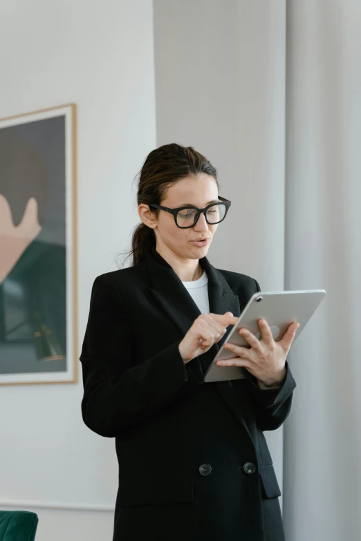 a woman in black blazer holding a digital tablet