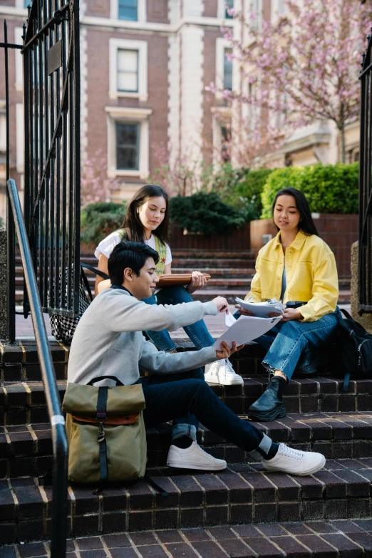 three people sitting outside on stairs having a conversation