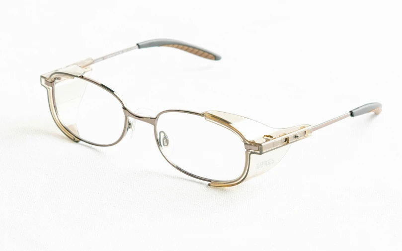 an old pair of glasses sitting on a white surface