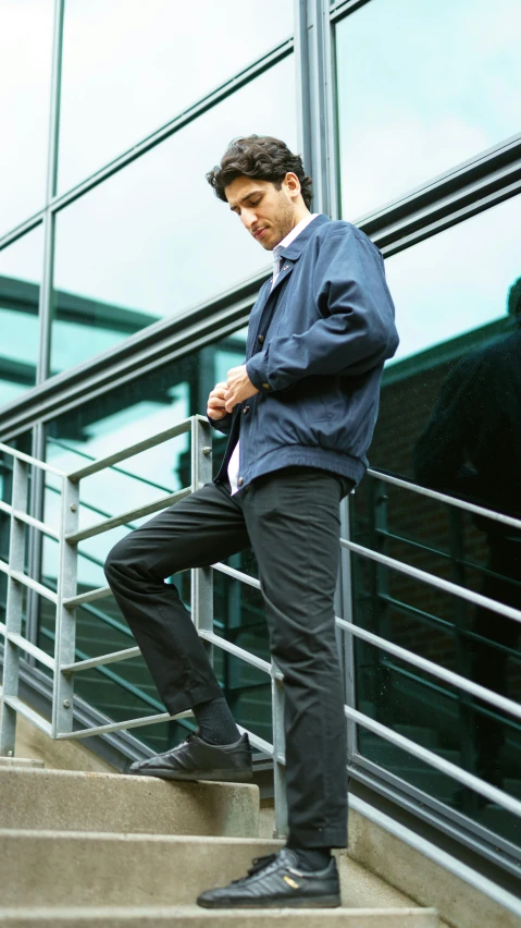 a man standing on a railing by some stairs