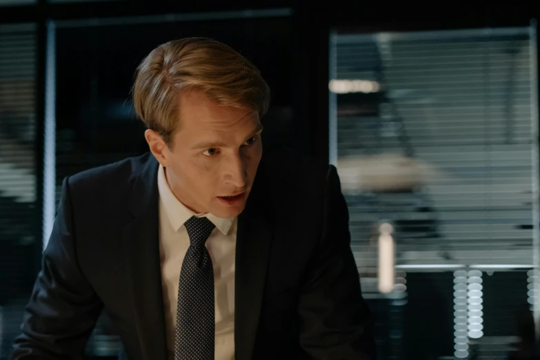 a man with a suit and tie sitting at a table