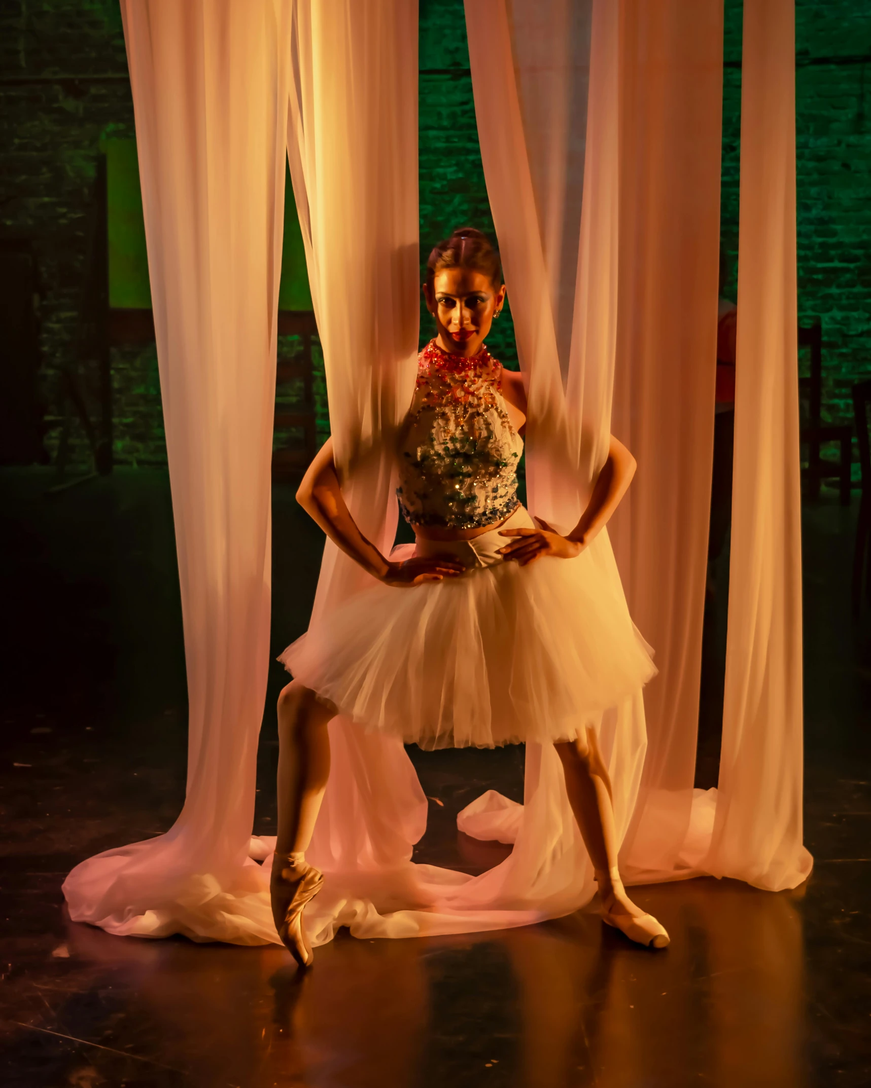 a dancer is posed in front of some curtains