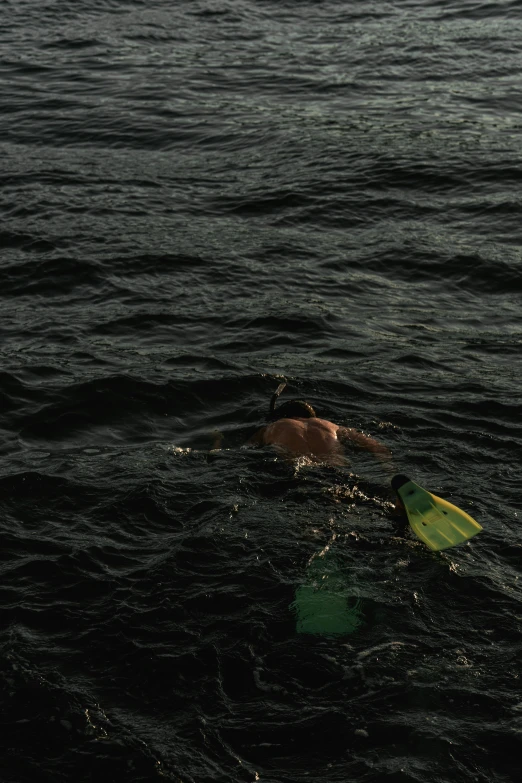 a man is on his stomach in the water with a surfboard