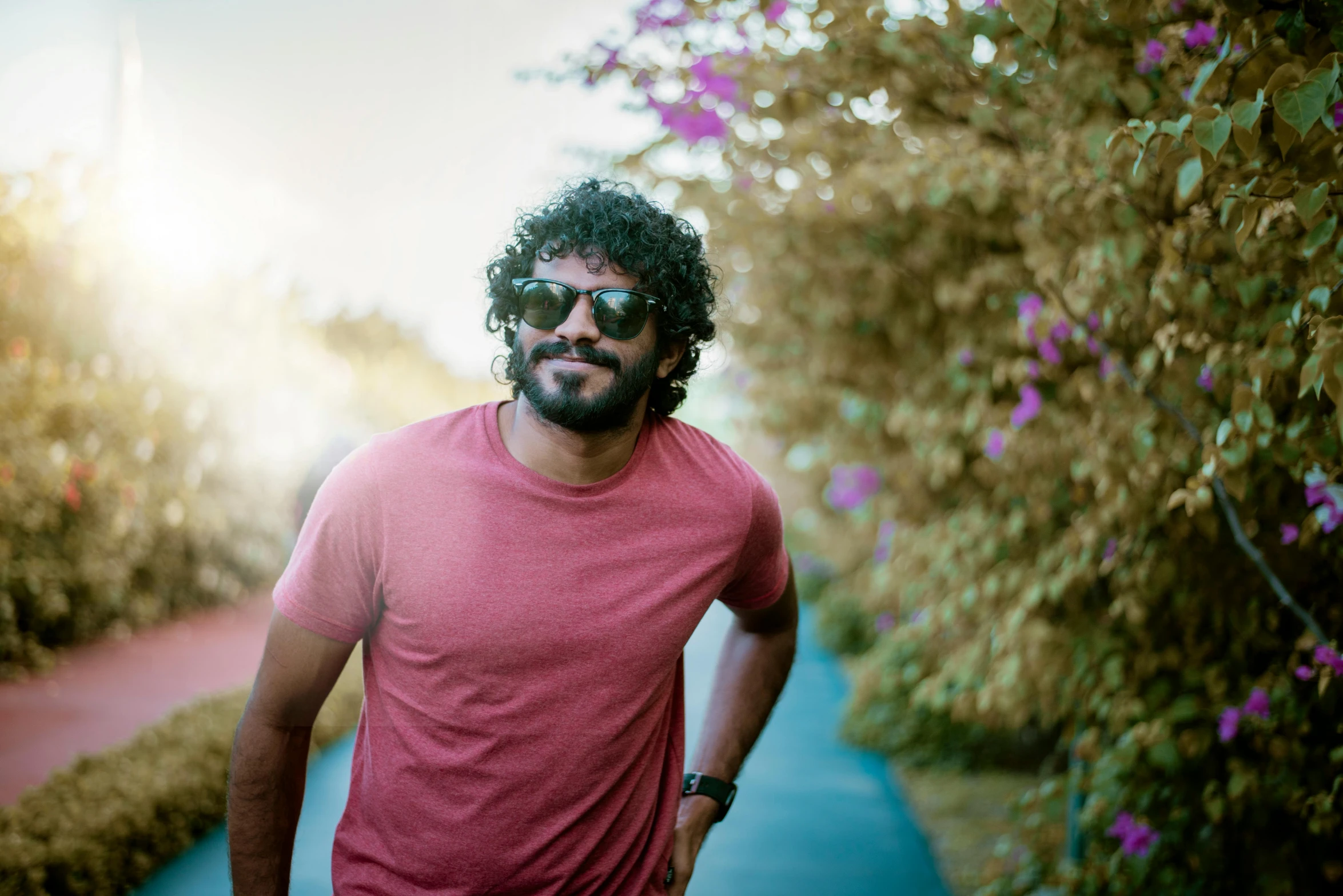 a man in a red shirt and sunglasses standing outside