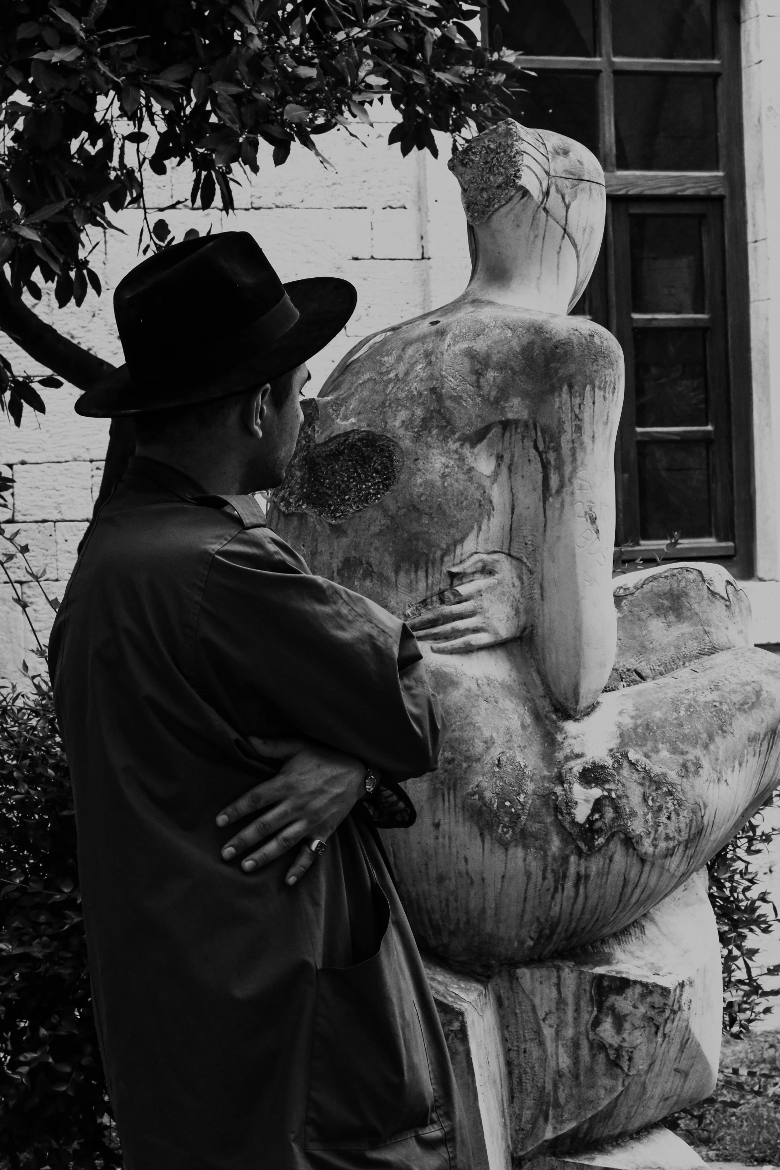 a man leaning against a stone statue