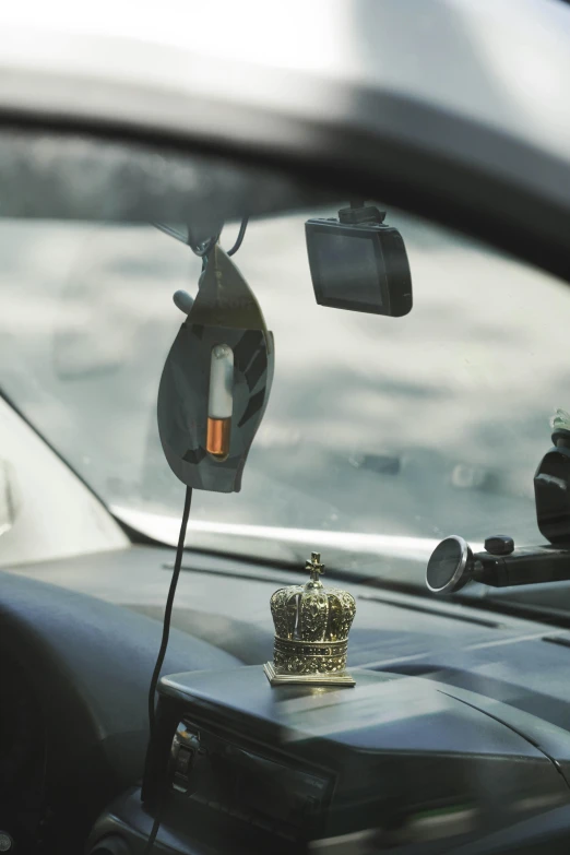 crown plugged in to a vehicle's dashboard with other items on it