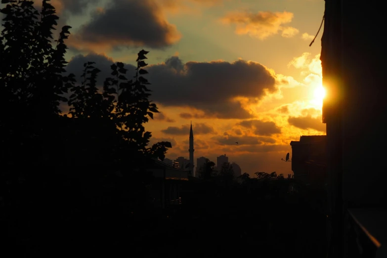 the sun sets behind the buildings in the city