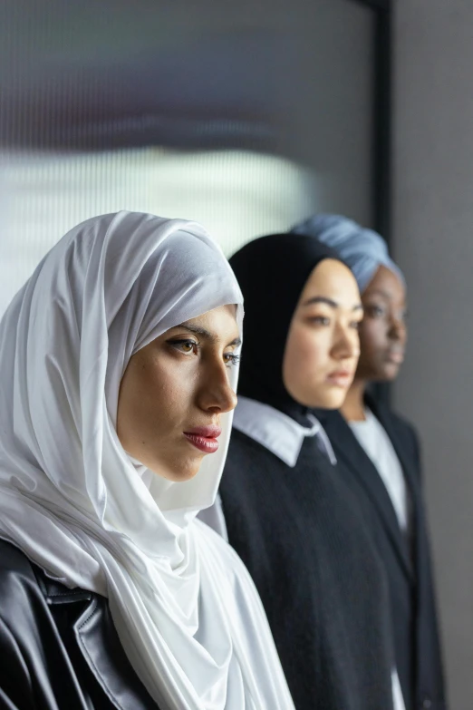 two women in hijabs standing with one holding onto another