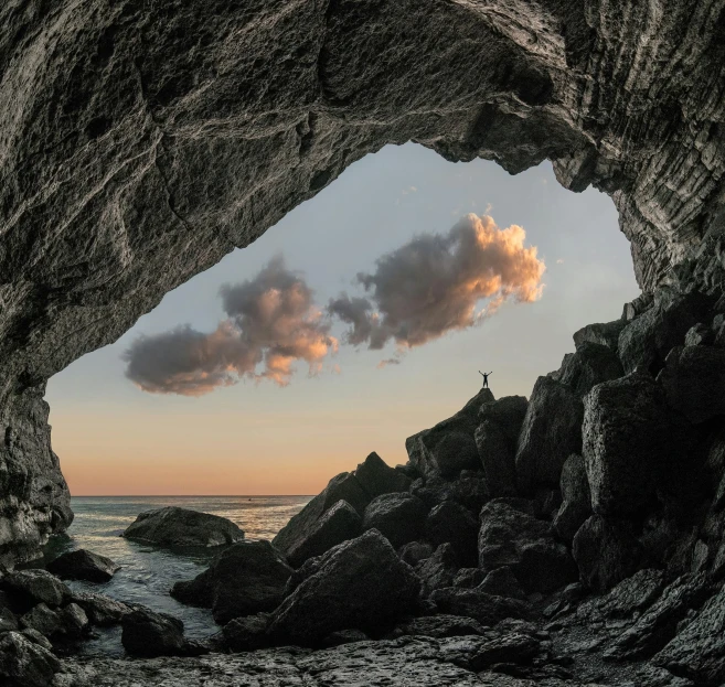 a small cave with water inside near rocks