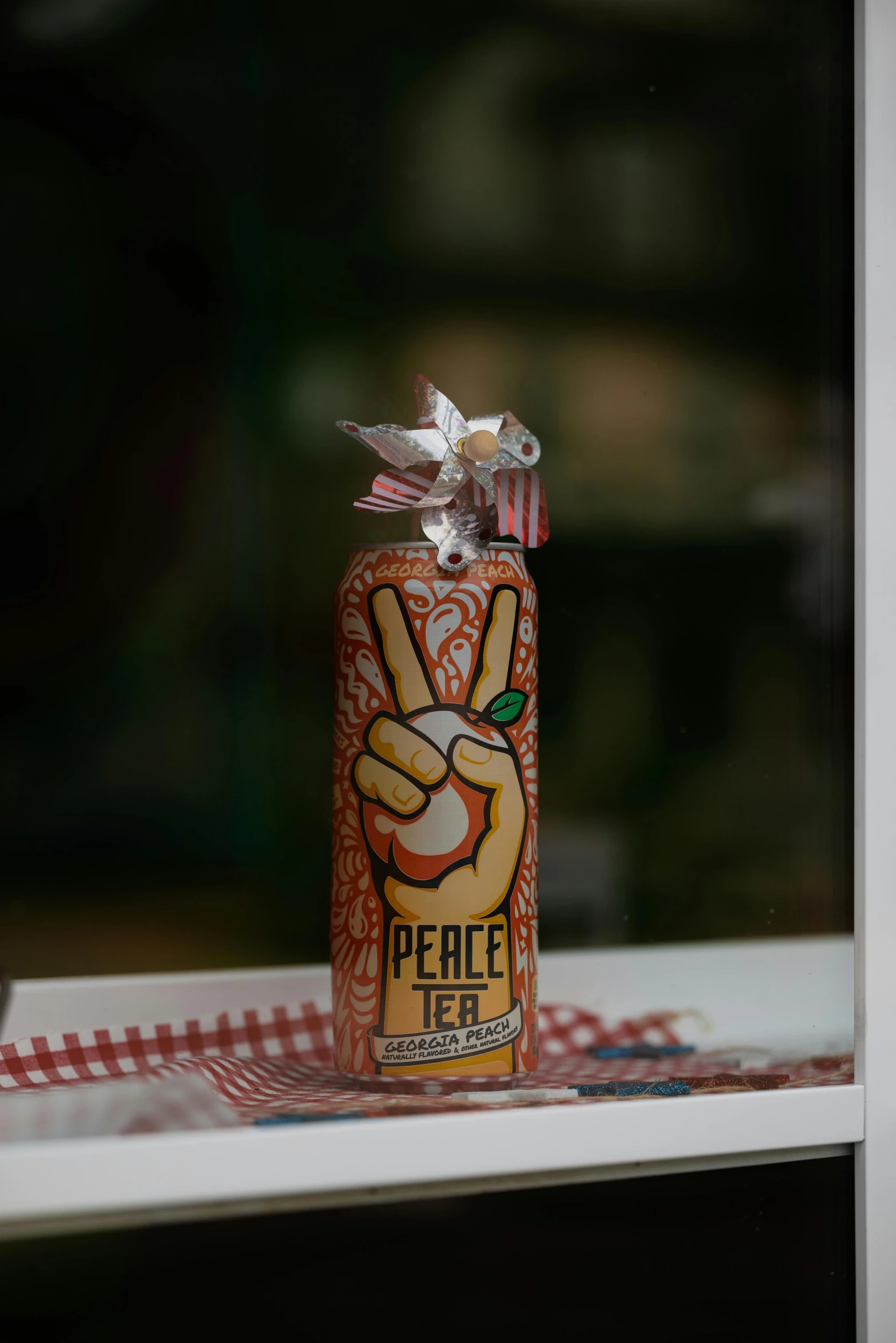 a glass bottle of peace tea is sitting on the windowsill