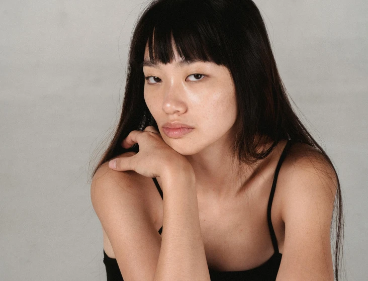 a woman poses for a portrait in a tank top