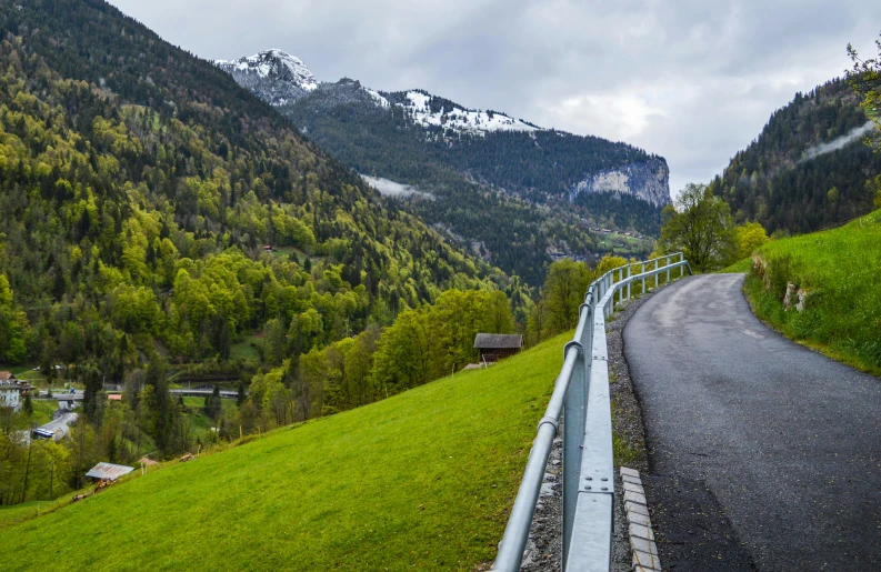 the road passes through a lush valley in the mountains