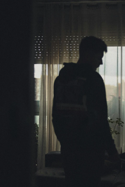 a man with a backpack stands in front of a window