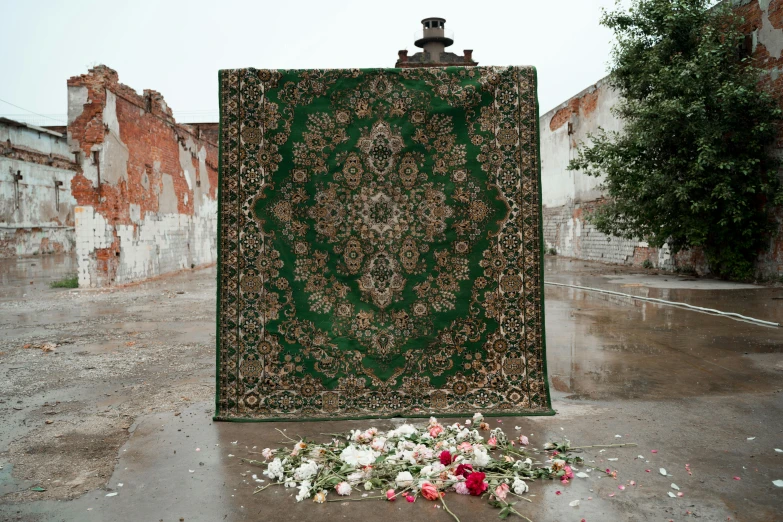 this is a carpet on a sidewalk with flowers nearby