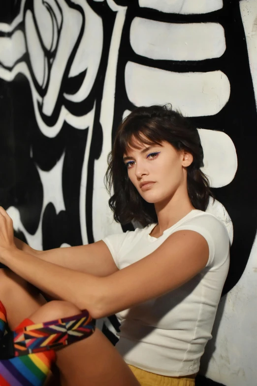 a young woman painting a colorful bird on the wall