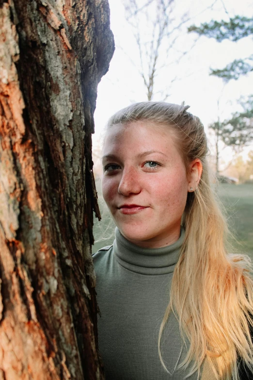  poses with a tree as background