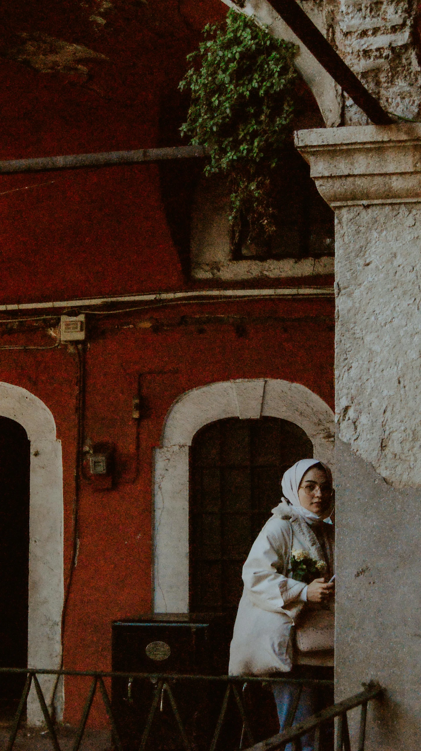 a woman standing outside a building in a white outfit