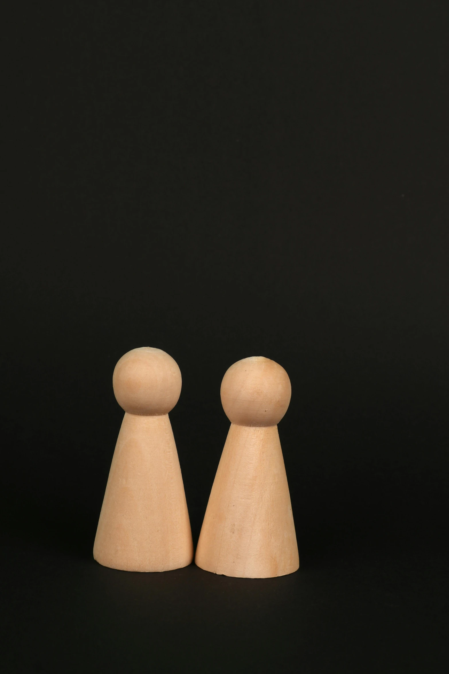 pair of wooden pegs on black background