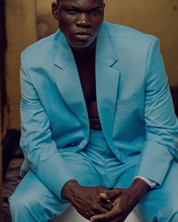 man with black face sitting on white chair outside