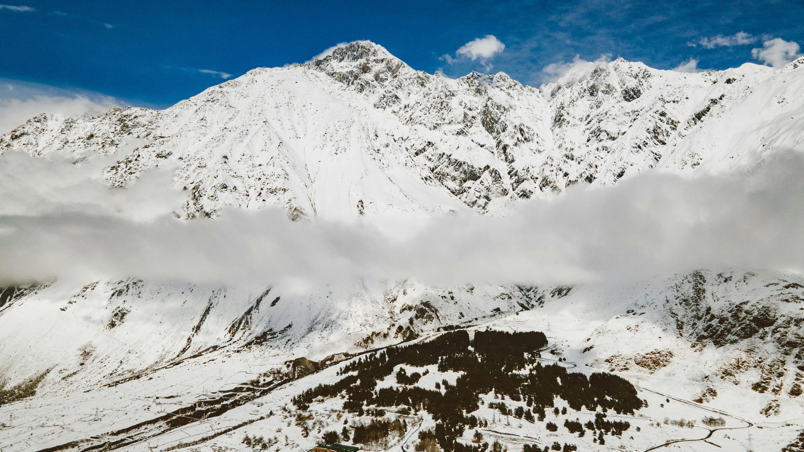 the view of snowy mountains and clouds during the day