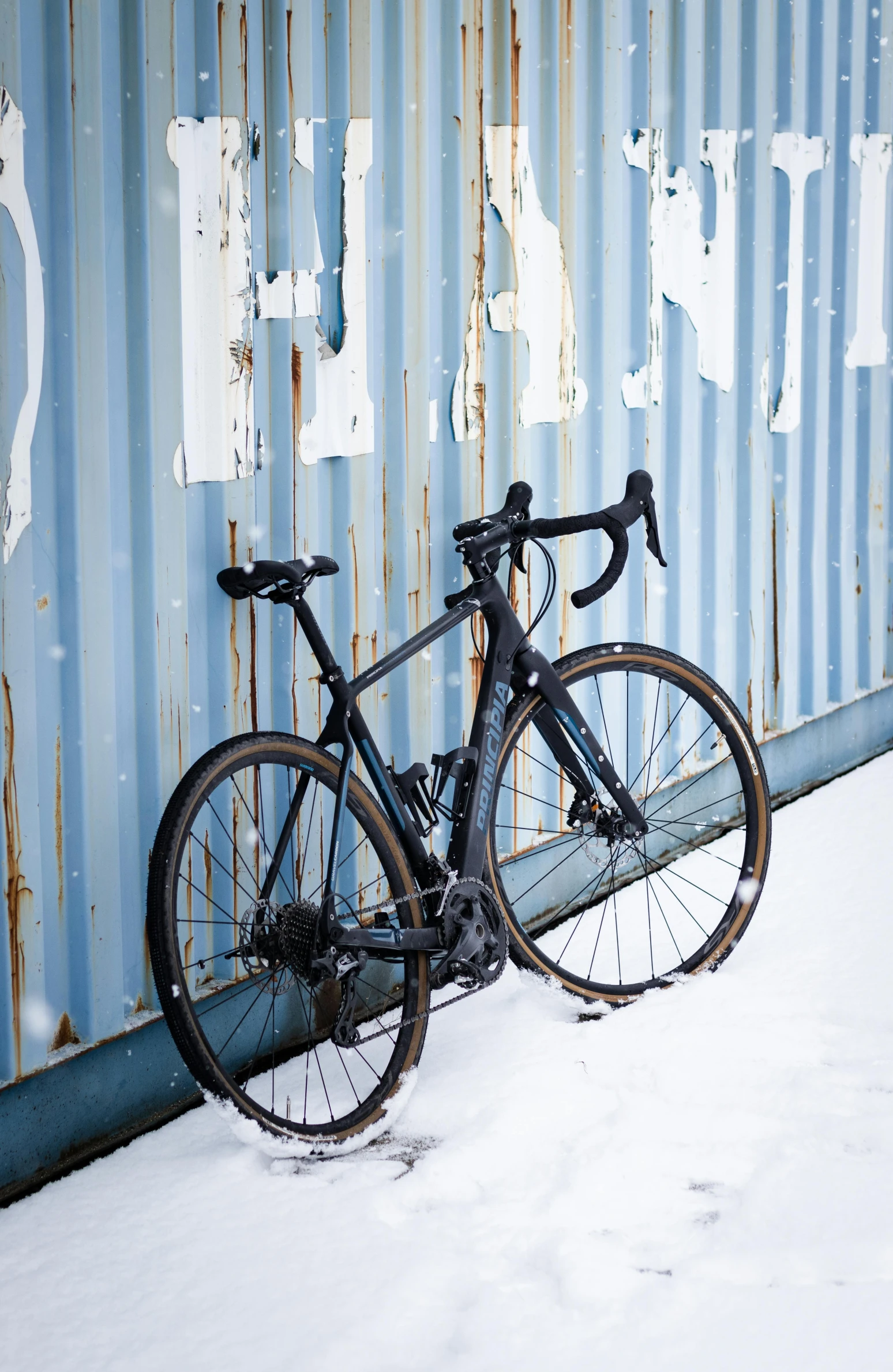 a bike is propped up against a blue wall