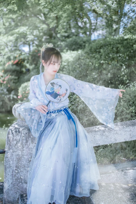 a woman in a blue gown is holding a snow globe