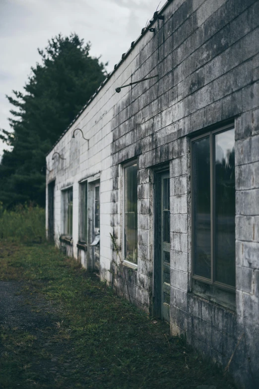 an old abandoned building sitting on the side of a road