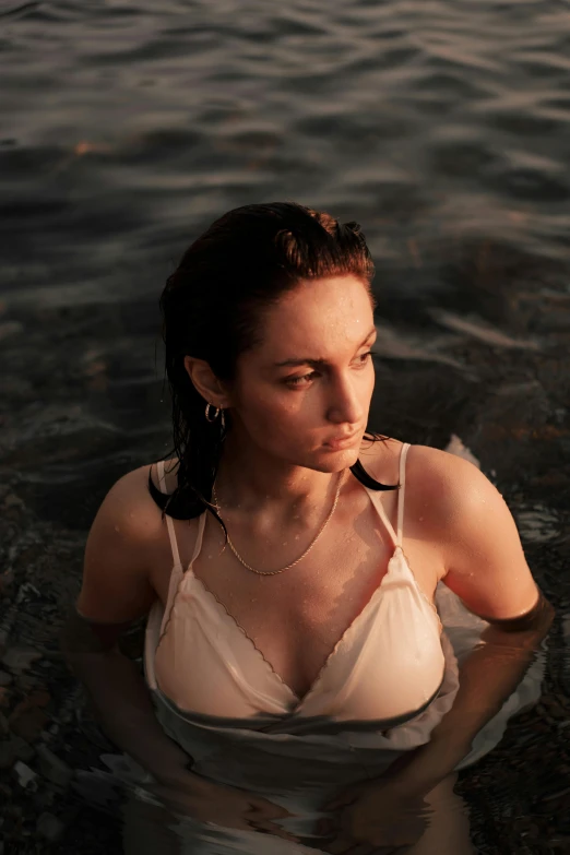 a woman is sitting in the water looking to her left