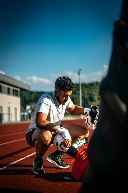 a man crouching down on the side of a track