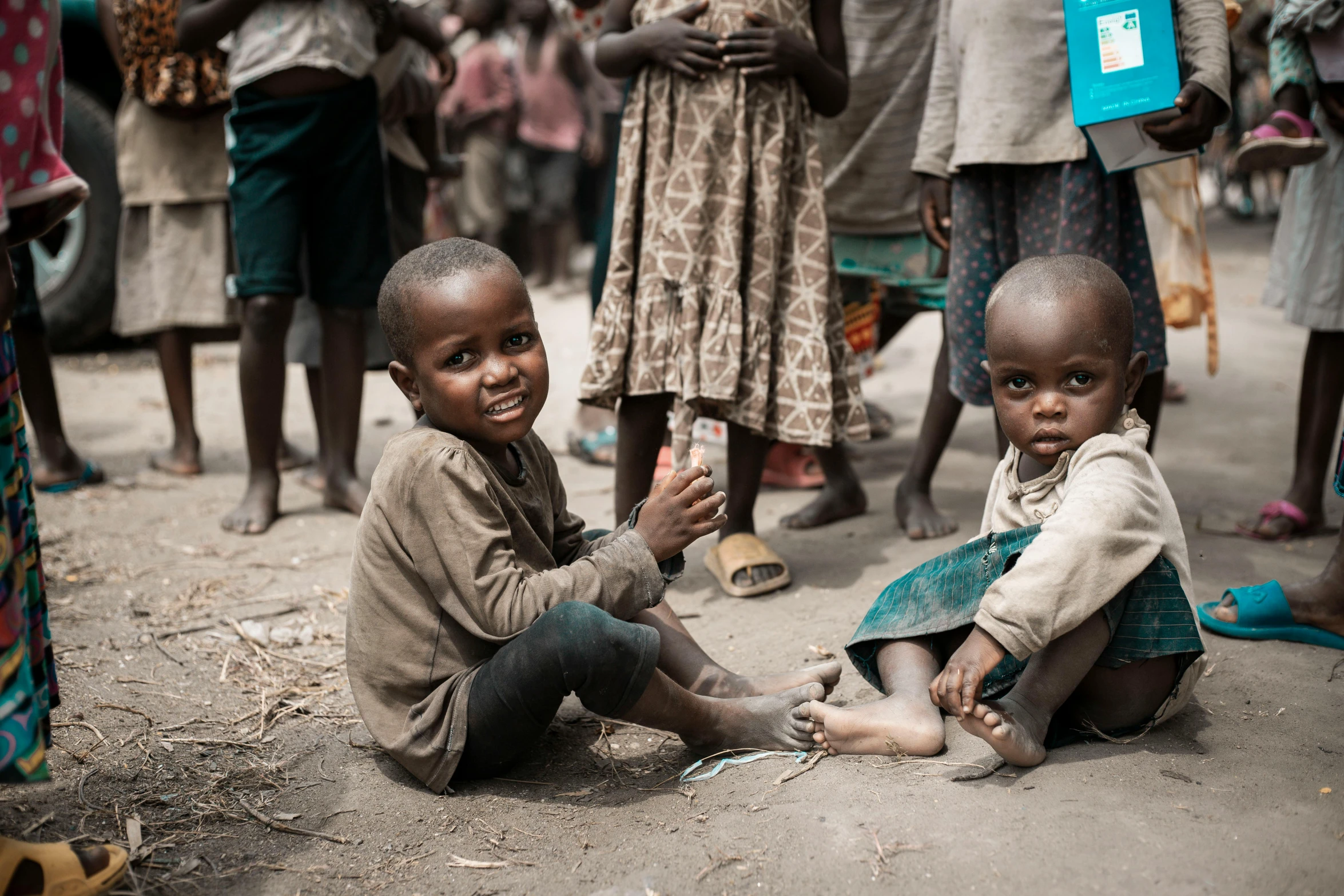 two little s sit on the ground with their feet crossed