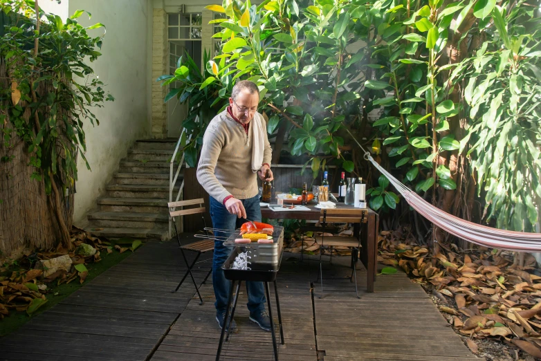 the man is grilling on the wood deck