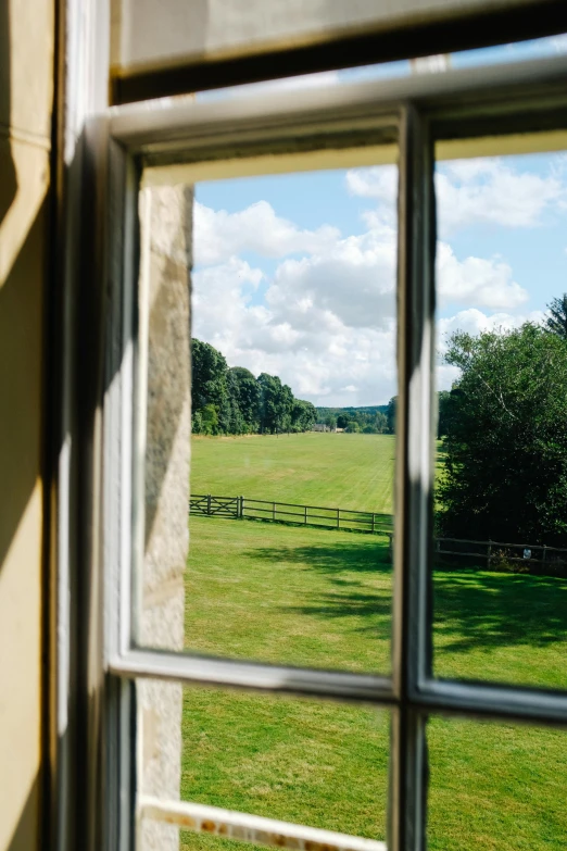 a grass field seen through the window of a building