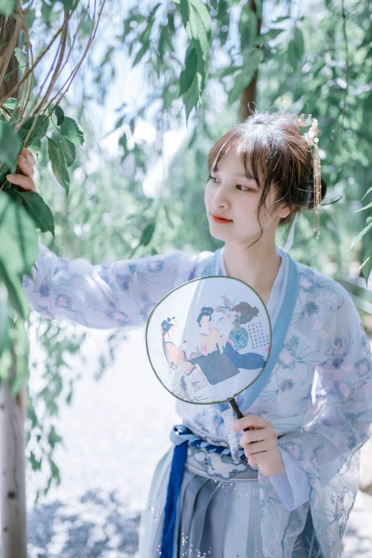 a woman in a blue dress is holding a fan