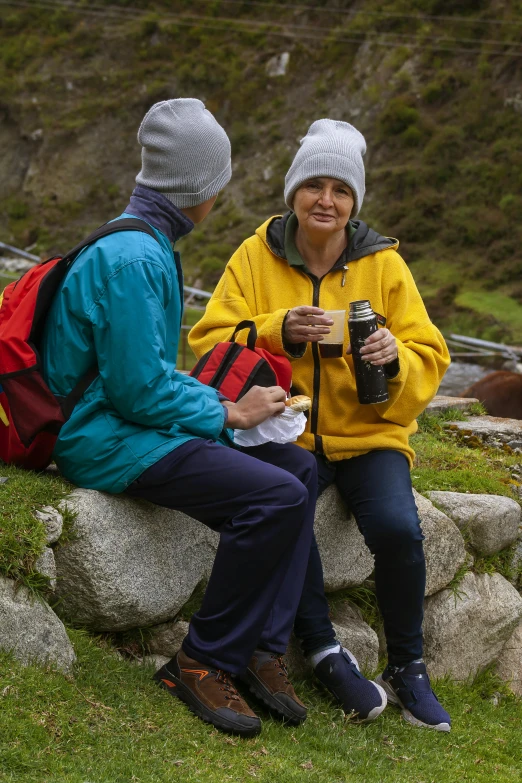 a couple of people that are sitting on a rock