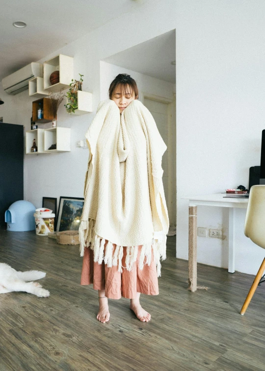 a woman wrapped in a blanket standing on the floor