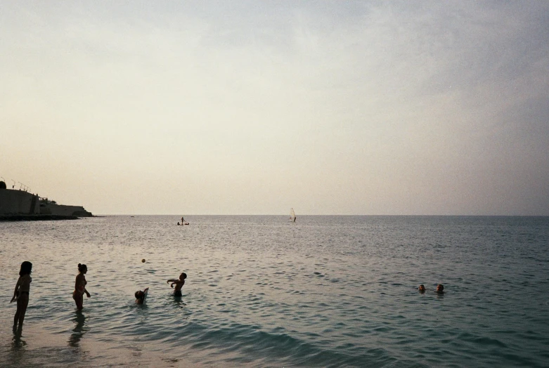 people playing in the water near a sandy beach