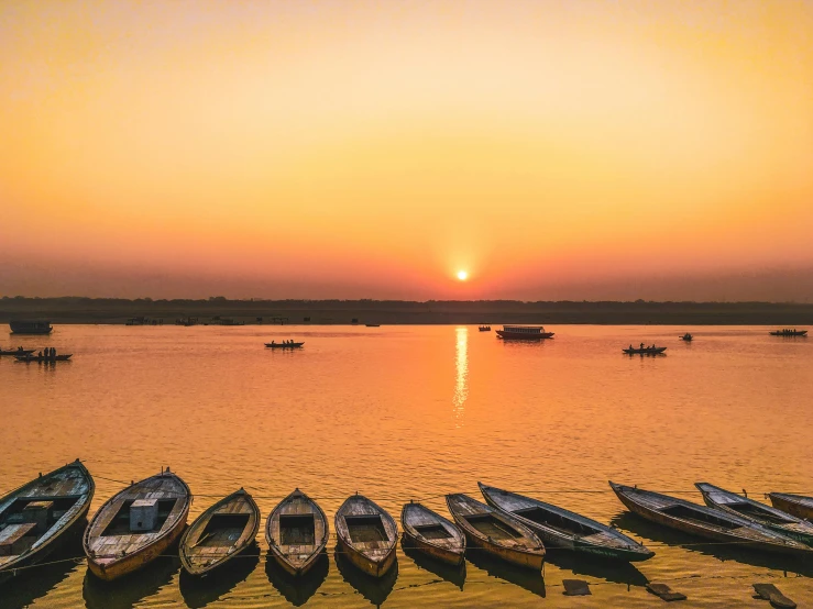 several boats on the shore at sunset