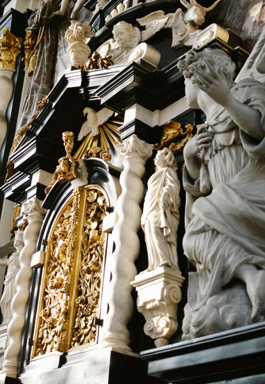 statue on pillar in large cathedral with white and gold decorations