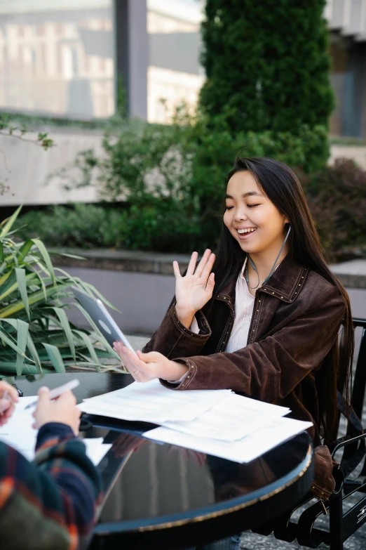 a woman talks to another woman at a table