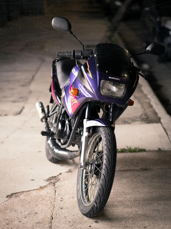 a purple motorcycle parked on the side of a road