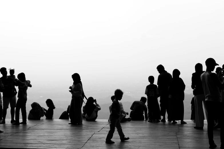 a group of people standing around each other in front of a hazy sky