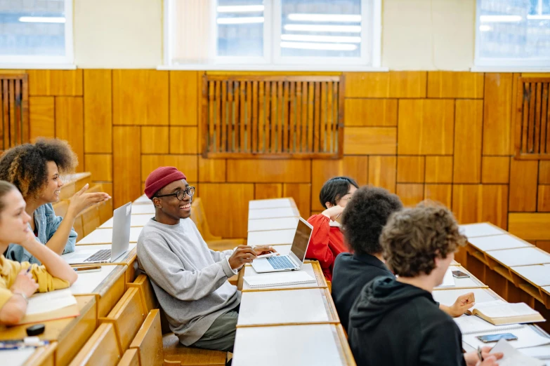 a number of people sitting at desks in a lecture hall