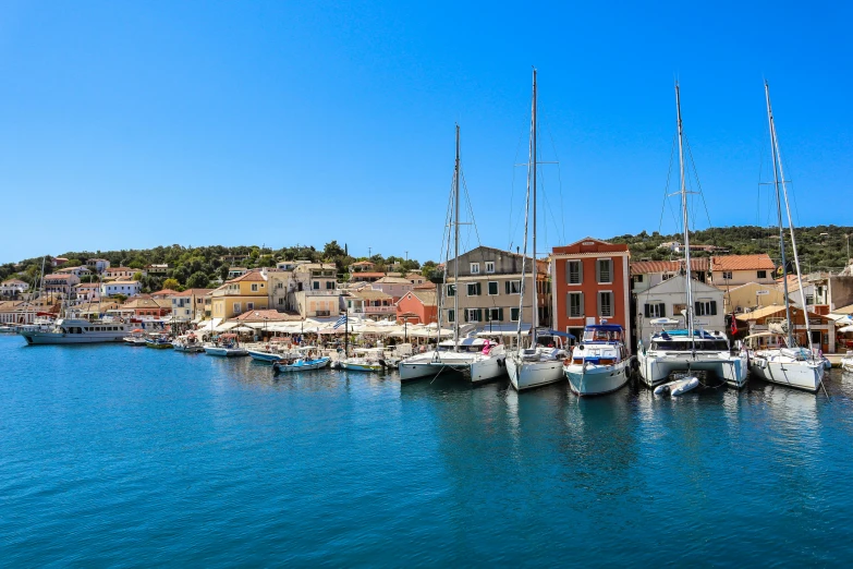 the small town is set up on a shore line on a clear, blue sea